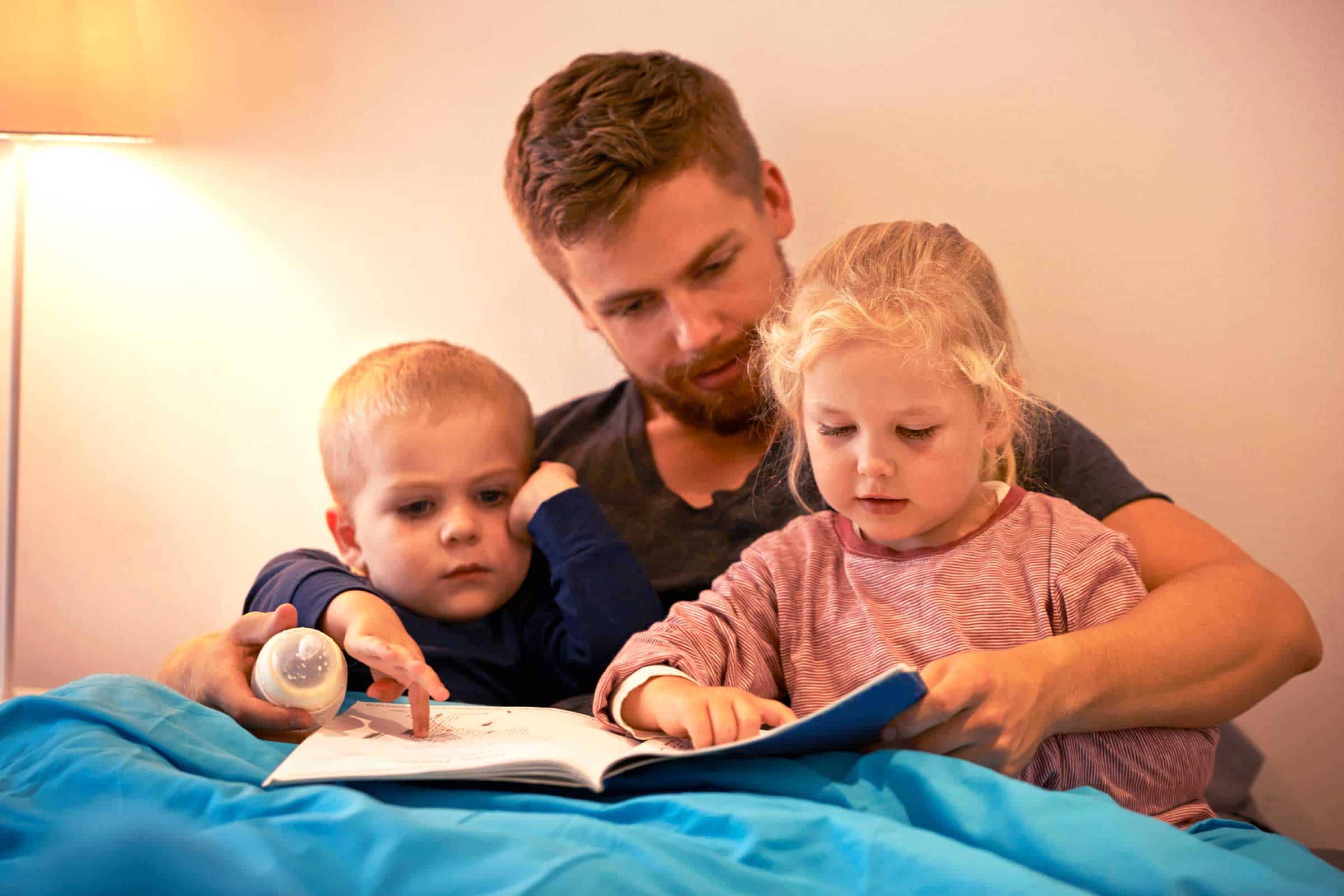 dad reading to his 2 young kids
